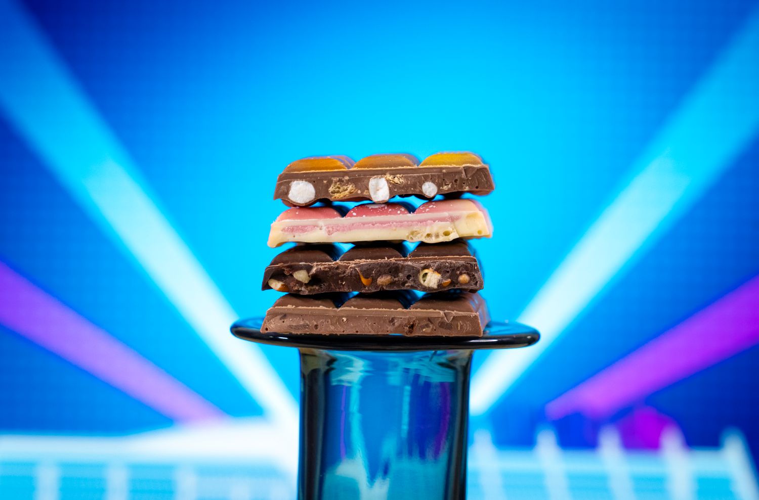 Four flavors of chocolate bars cut in half and stacked on a pedestal